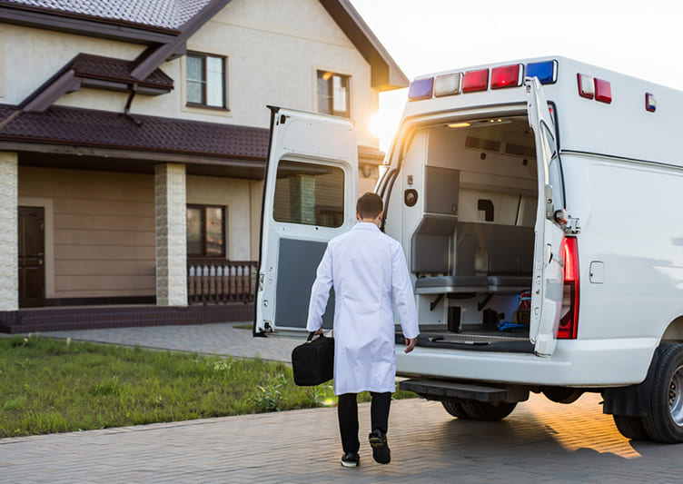 Врач выходит из скорой помощи и направляется к дому, вид со спины